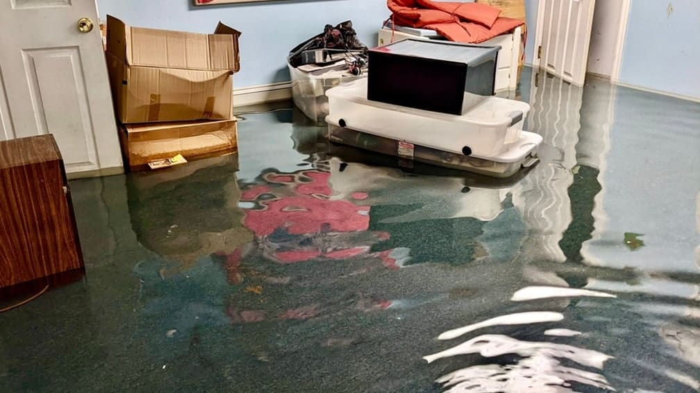 Flooded basement with damaged items.