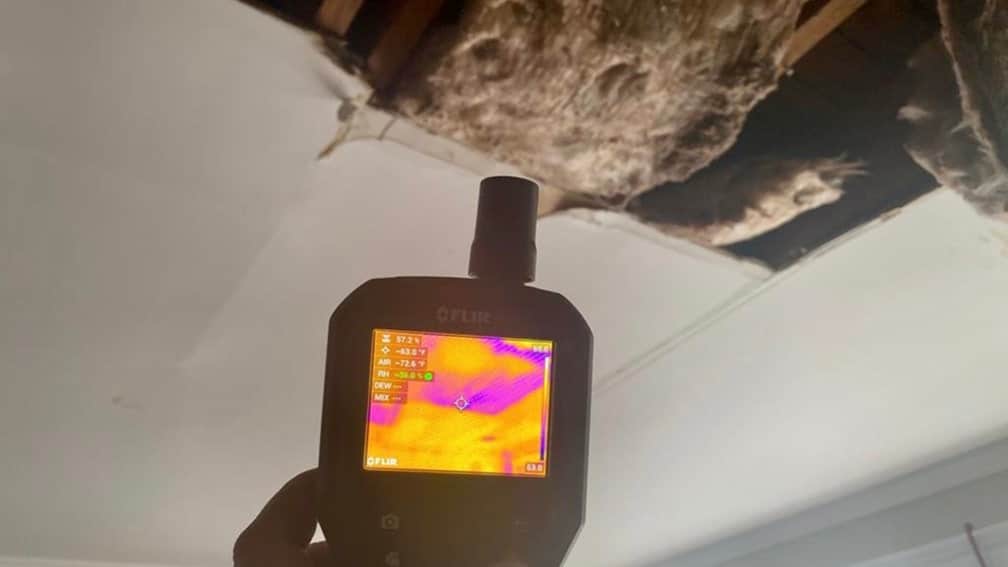 thermal imaging device pointed at burst pipe and ceiling water damage